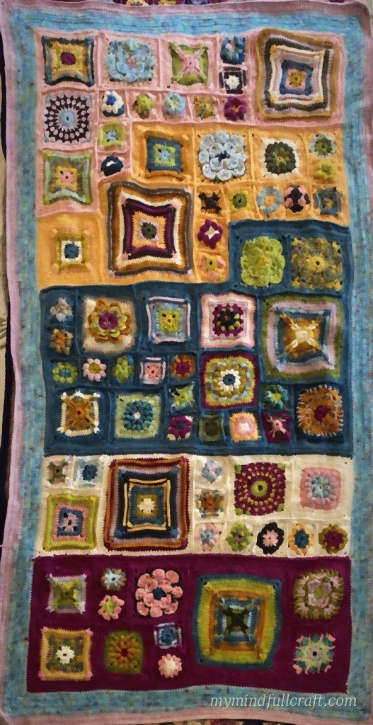 Sampler blanket of colourful crochet squares and flowers